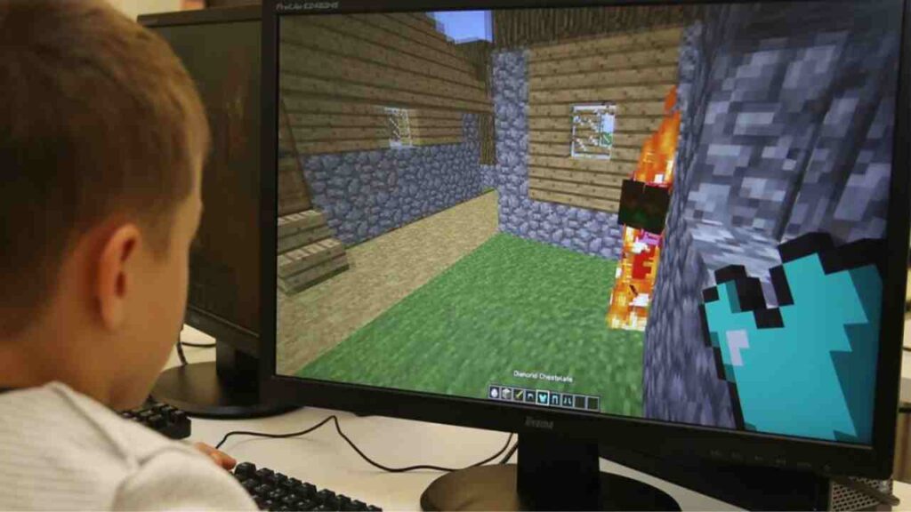 A kid is playing Minecraft and creating things and enjoying the gameplay. 